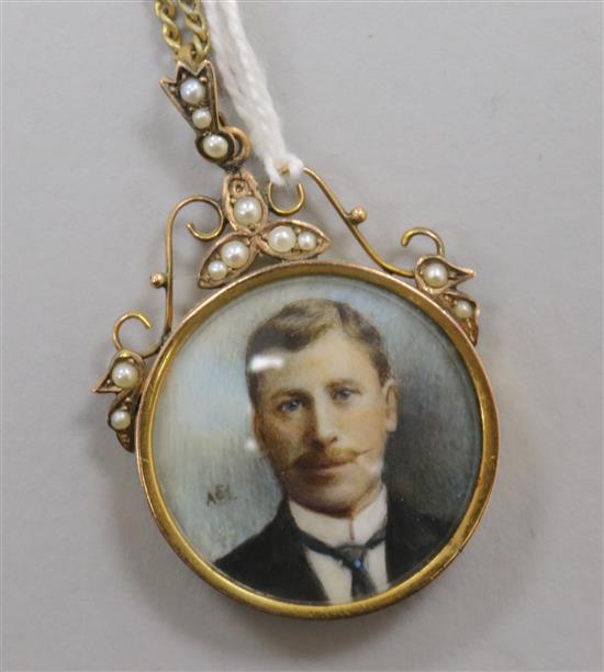 An Edwardian gold framed double sided portrait locket, inset with split pearls, on a gilt metal chain.